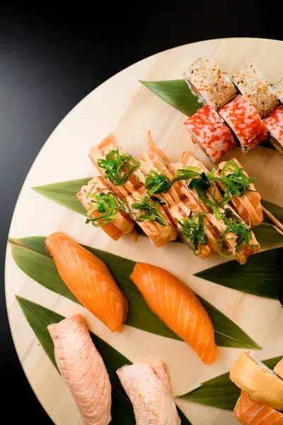 Různé Sushi Rolky Podávané Kulaté Dřevěné Desce Izolované Tmavém Pozadí — Stock fotografie