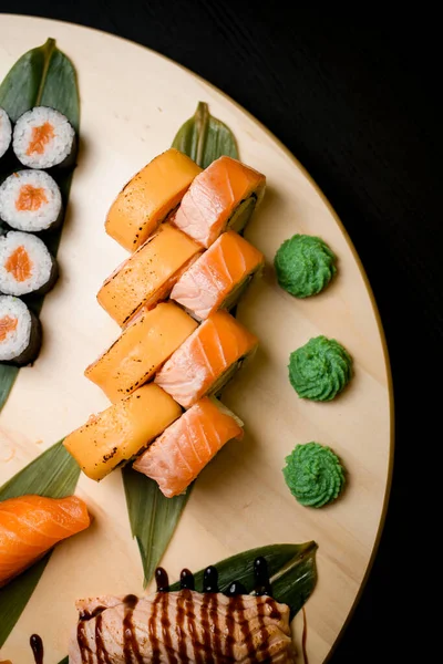 Různé Sushi Role Kulaté Dřevěné Desce Izolované Černém Pozadí Stolu — Stock fotografie