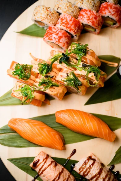 Různé Sushi Rolky Krabí Tyčinky Kulaté Dřevěné Desce Izolované Černém — Stock fotografie