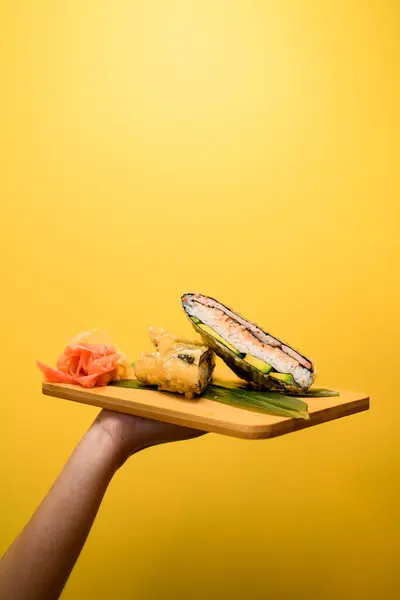 Tangan Wanita Memegang Papan Dengan Dua Bagian Dari Sandwich Sushi — Stok Foto