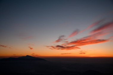 Atmosferik altın alacakaranlık gökyüzü kışın akşamında dağların üzerinde bulutlar ve sis ile. İnanılmaz bir doğa. Kış mevsimi
