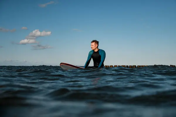 Mladý Muž Surfař Neoprénu Sedí Surfu Moři Čeká Blížící Vlnu — Stock fotografie