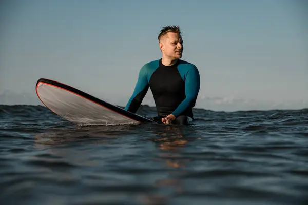 Usmívající Pohledný Mladý Muž Surfař Neoprénu Sedí Moři Surfu Zamyšleně — Stock fotografie