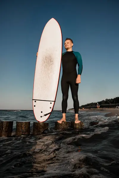 Hezký Mladý Muž Surfař Neoprénu Stojící Dřevěném Pařezu Drží Surfovací — Stock fotografie