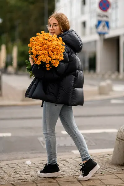 สาวผมด าในแจ คเก รองเท าใบส นตาและกางเกงย อมช อดอกไม เหล องท — ภาพถ่ายสต็อก