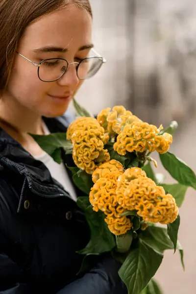 อดอกไม เหล องสดใสในม อของผ งบร นอย บนถนนในว นฤด ใบไม วงในภาพถ — ภาพถ่ายสต็อก
