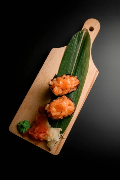 Daun Hijau Panjang Papan Kayu Dengan Sushi Berlatar Belakang Hitam — Stok Foto