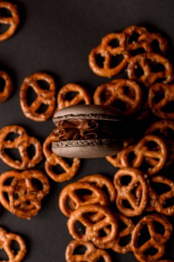 Çikolata kremalı Fransız çörekleri siyah arka planda rastgele saçılmış krakerlerin arasındadır.