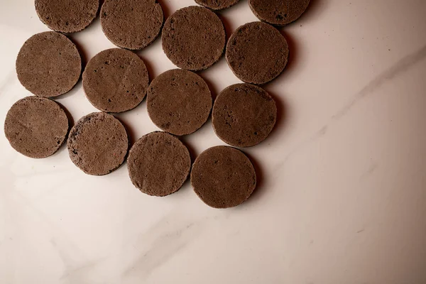 Круглі Половинки Шоколадних Макарунів Лежать Білій Поверхні Столу Догори Ногами — стокове фото