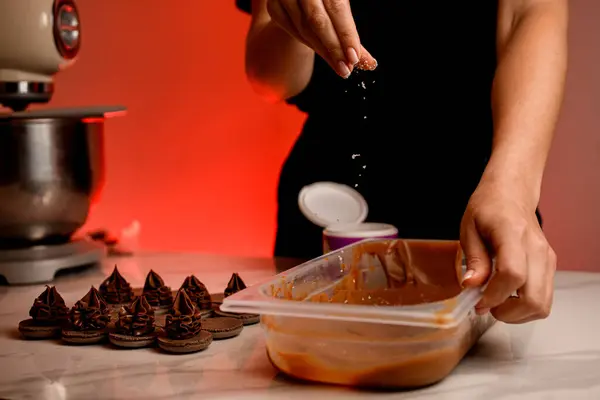 Penyemprot Tangan Wanita Memercikkan Krim Coklat Dalam Wadah Plastik Meja — Stok Foto