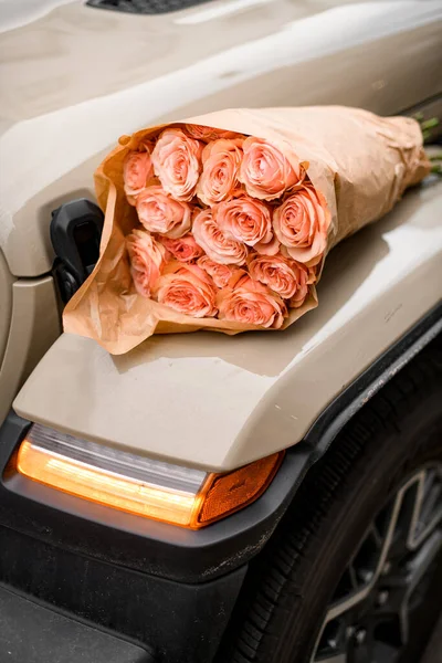 Tenderness and passion in one bouquet of sweet roses on a vintage car on the street. Composition of charming flowers