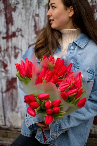 Wanita Cantik Berambut Cokelat Memegang Beberapa Karangan Bunga Tulip Merah — Stok Foto