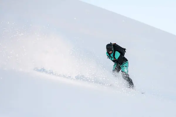 男子单人滑雪板滑行在斜坡上 左右漂移 滑行在雪板上 使得雪片飞向不同的方向 — 图库照片