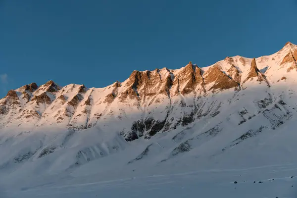 美丽的山坡 被岩石切割 风从那里吹散了蓝天背景下的雪 — 图库照片
