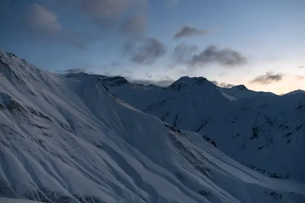 Flera Snöiga Backar Bakgrunden Mörk Himmel Med Små Moln Efter — Stockfoto