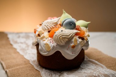 Mavi-pembe makaronlu pasta, kremalar, şekerli meyveler ve badem dolgulu ve masada narin krema.