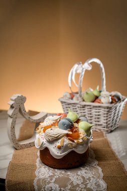 Tatlı kremalı pasta, beyaz dantelli ve kaba çuval bezi ve beyaz sepetli badem kurabiyesi.