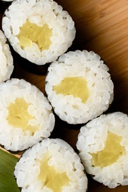 Diğer suşi türlerinin yanında ahşap bir tahtaya ışık dolu bir suşi porsiyonu.