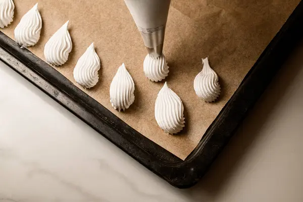 Meringue Kue Dengan Warna Putih Membuat Kertas Perkamen Atas Meja — Stok Foto