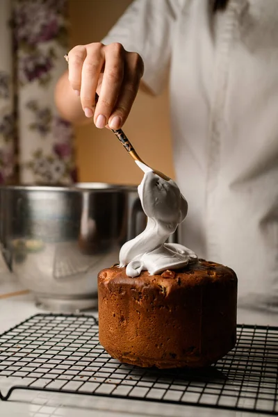 女厨师在大理石桌上用蓬松的白色厚奶油装饰一个小杏仁面饼 — 图库照片