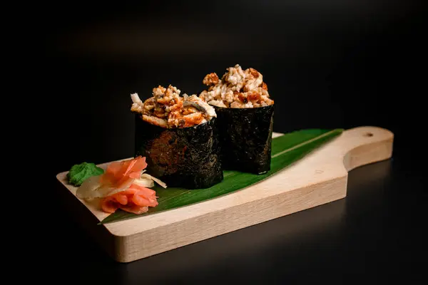 Sushi Gulungan Ditaburi Dengan Potongan Goreng Ikan Yang Disajikan Daun — Stok Foto