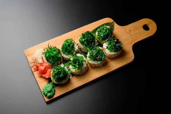 Sebagian Sushi Gulung Dengan Tumpukan Ganggang Hijau Dan Jahe Dan — Stok Foto