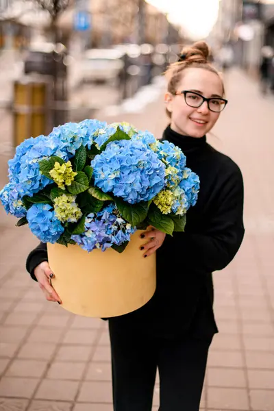 Çiçekçi Kadın Ellerinde Mavi Ortanca Buketi Olan Bir Şapka Kutusu — Stok fotoğraf
