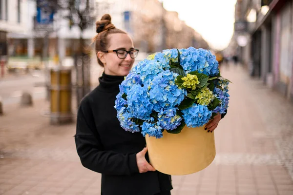 Çiçekçi Kadın Ellerinde Mavi Ortanca Buketi Olan Bir Hediye Kutusu — Stok fotoğraf