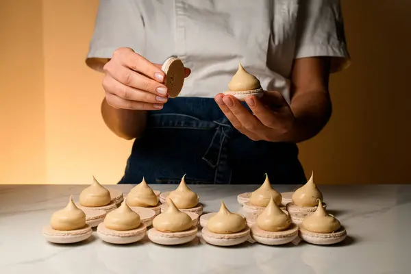 Femme Cuisinière Fixe Les Moitiés Macarons Enduits Crème Sur Une — Photo