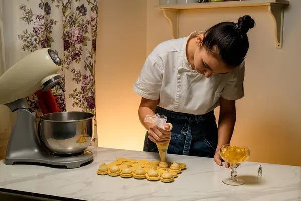 Perempuan Confectioner Membungkuk Atas Meja Dapur Dan Meremas Krim Beige — Stok Foto
