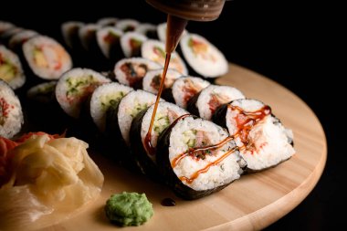 Tahtadaki salatalık, karides, wasabi ve zencefilli maki ön planına odaklan.