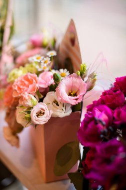 Posta kutusu şeklinde bir hediye kutusundaki güzel çiçek buketi bulanık bir pencerenin pervazında duruyor.