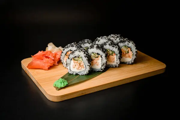 Sushi rolls filled with pieces of fish and fresh cucumber, accented with black sesame seeds