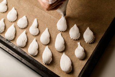 Uzman eller çeşitli lezzetli tatlılar yaratmak ve şekillendirmek için ustalıkla bir pasta torbası kullanırlar..