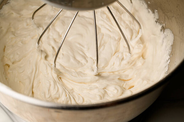 The cream whipping process is captured in motion, showing the transformation into fluffy whipped cream.