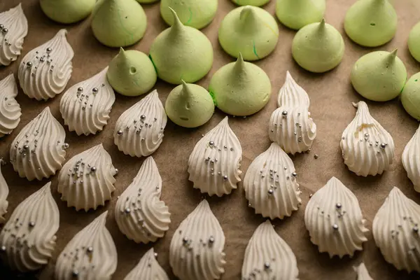 Kireç konisi şeklinde krema ve fırında pişirilmiş hamur işi parşömeninin üzerinde beyaz yapraklar.