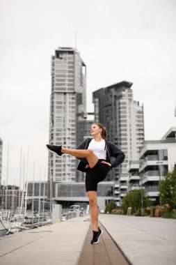 Göz alıcı bir performansta, atletik kız büyüleyici pozuyla iskelede dikkat çekiyor..