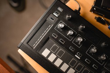 Bulanık zemin arkaplanındaki müziği değiştirmek için farklı düğmeleri ve tuşları olan akor sentezleyicisinin üst görüntüsü
