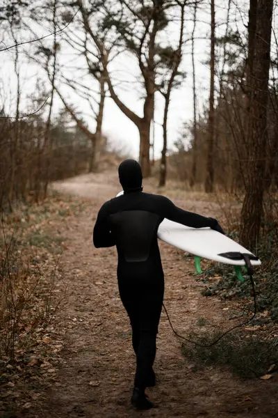 Mladý Surfař Neoprénu Kráčí Pěšině Mezi Stromy Ruce Drží Surf Stock Fotografie