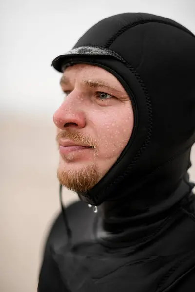 男性のサーファーは 防水クリームから水滴を示す顔をぼやけた背景に対して皮膚に適用 ストック画像