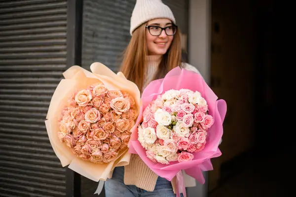 パステルピンクの2つの花束 白とライトベージュ色 魅力的な笑顔の少女の手で美しいバラ ストック写真