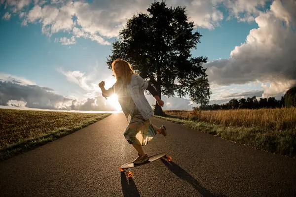 Basking Luz Sol Uma Menina Impulsiona Seu Longboard Para Frente Fotografias De Stock Royalty-Free