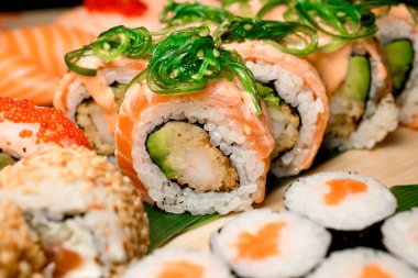 Çeşit çeşit suşi topluluğunun içinde lezzetli somon ruloları var. Nori ile tatlandırılmış, bir dizi cezbedici setin arasında..