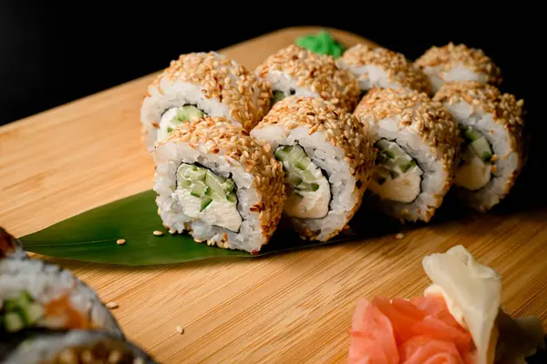 Indulge in a delightful combination of flavors with these sushi rolls featuring creamy Philadelphia cheese, crisp cucumber, and a finishing touch of sesame seeds.