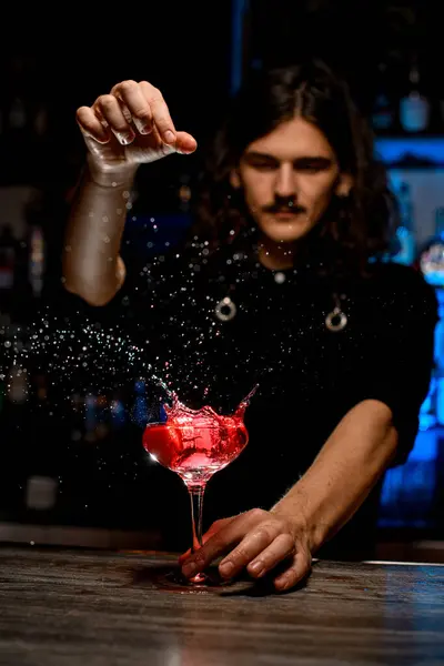Bartender Kastet Noe Fra Høyde Inn Glass Fylt Med Cocktail stockbilde