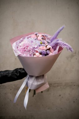 Harika pembe ve yumuşak lavanta çiçekleri. Siyah elbiseli bir kızın elinde pembe bir ambalajda.