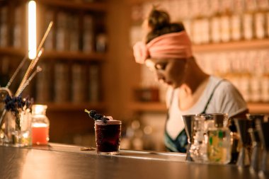 Üzerinde siyah bir içecek olan bir bardağa odaklan ve üzerinde böğürtlenli bir şiş olsun.