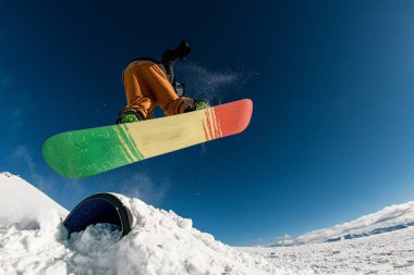 Bir sıçrama tahtasının gücüyle hareket eden snowboardcunun neşeyle sıçradığı anı yakalıyorum..