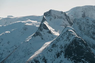 Birkaç karlı dağ zirvesinin üst manzarası. Parlak mavi gökyüzü ile dağlarda güneşli bir bahar günü