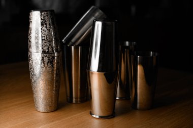 Masadaki diğer basit çelik titreticilerin yanında her tarafı güzel oymalı bir titretici üzerinde odaklan, bazıları parçalanmış.